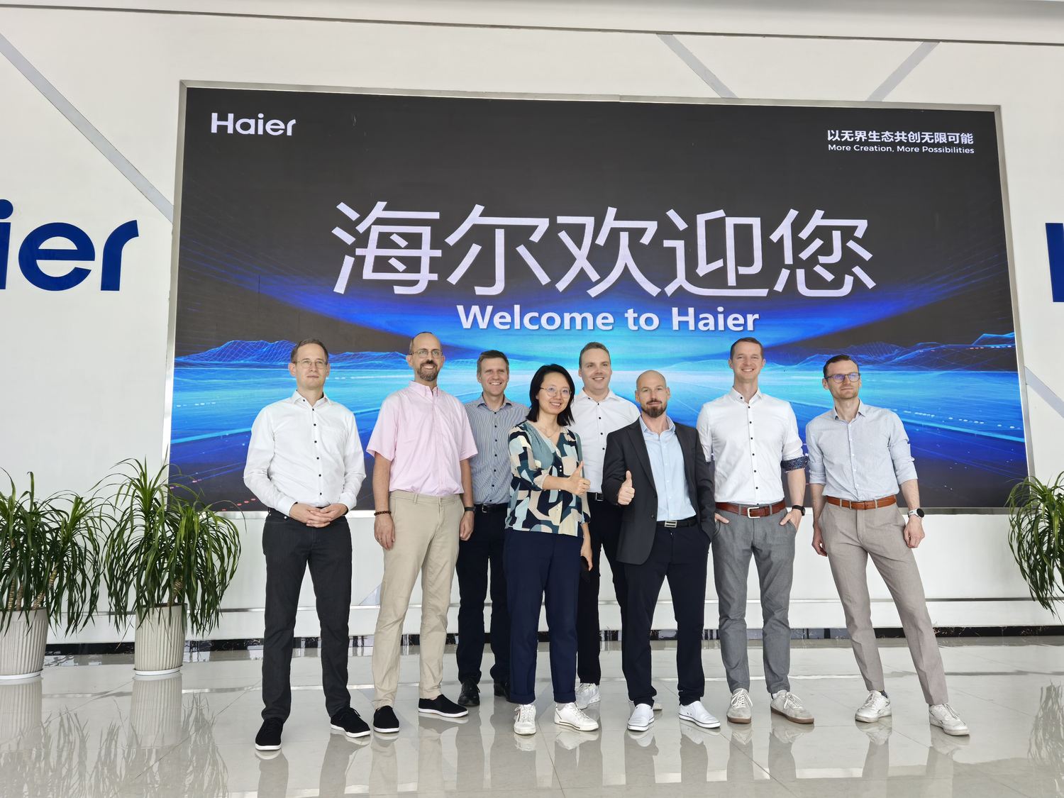 Gruppenfoto vor dem Haier-Willkommensbanner