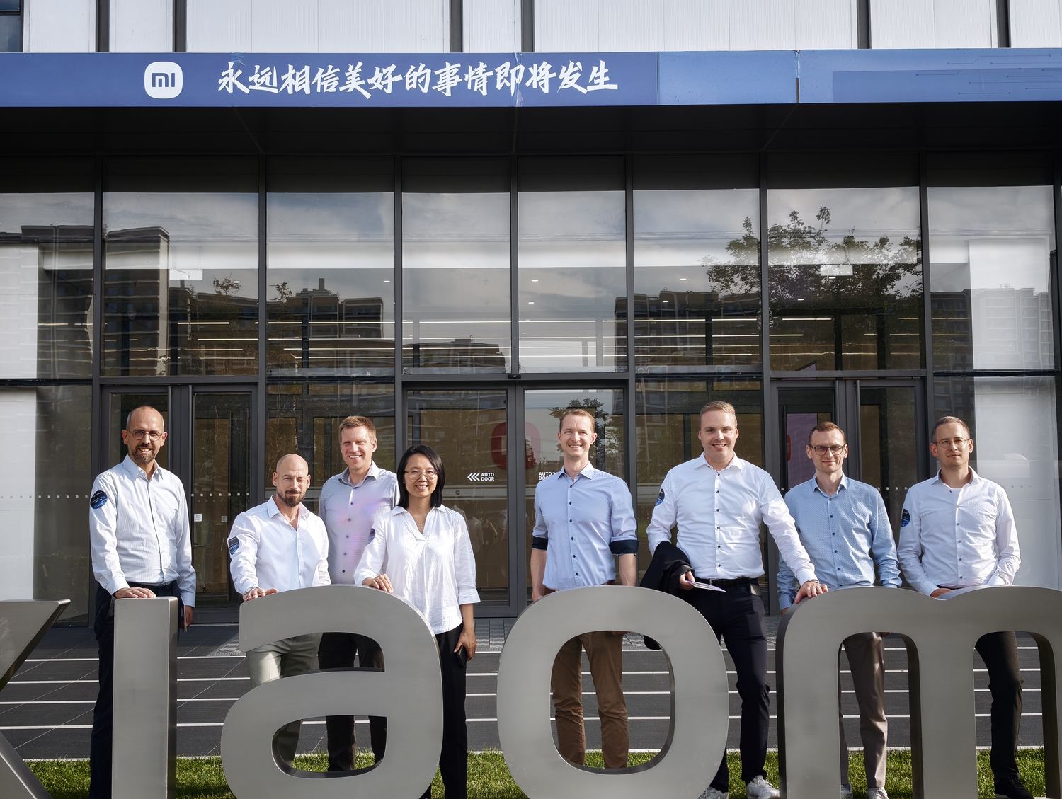 Gruppe vor dem Xiaomi-Schriftzug am Werk