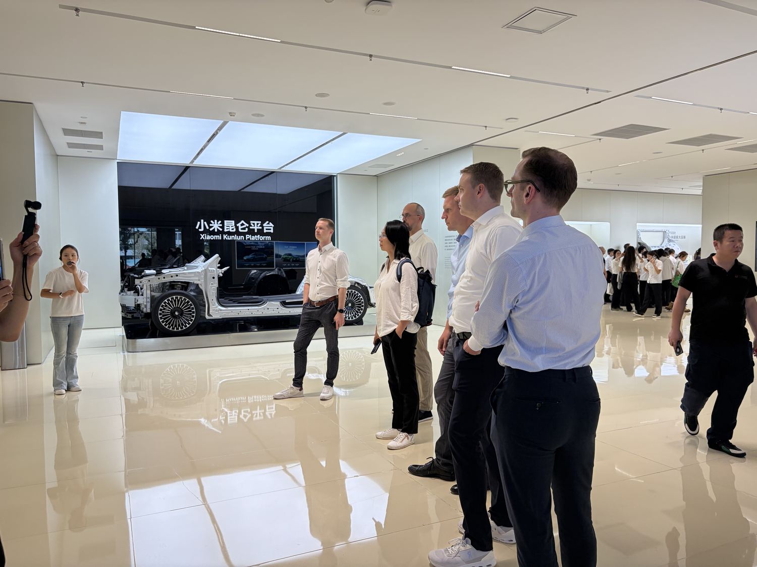 Teilnehmende vor der Xiaomi-Kunlun-Fahrzeugplattform